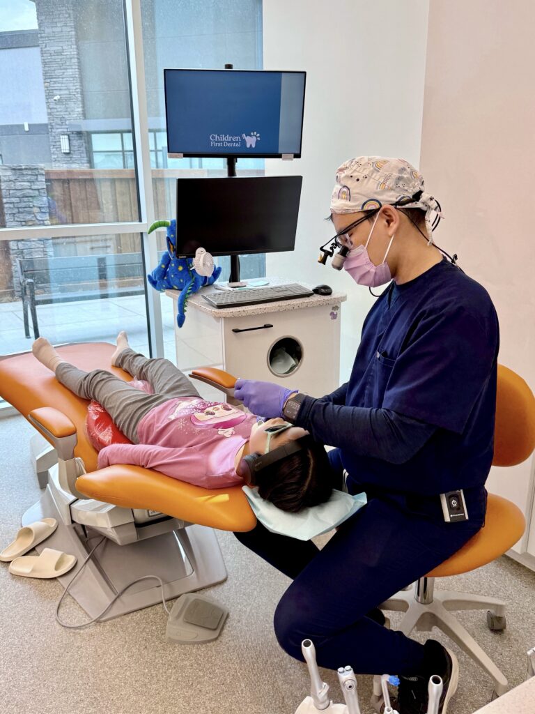 Dr. Wong providing pediatric dental care to a child at Children First Dental in Edmonton